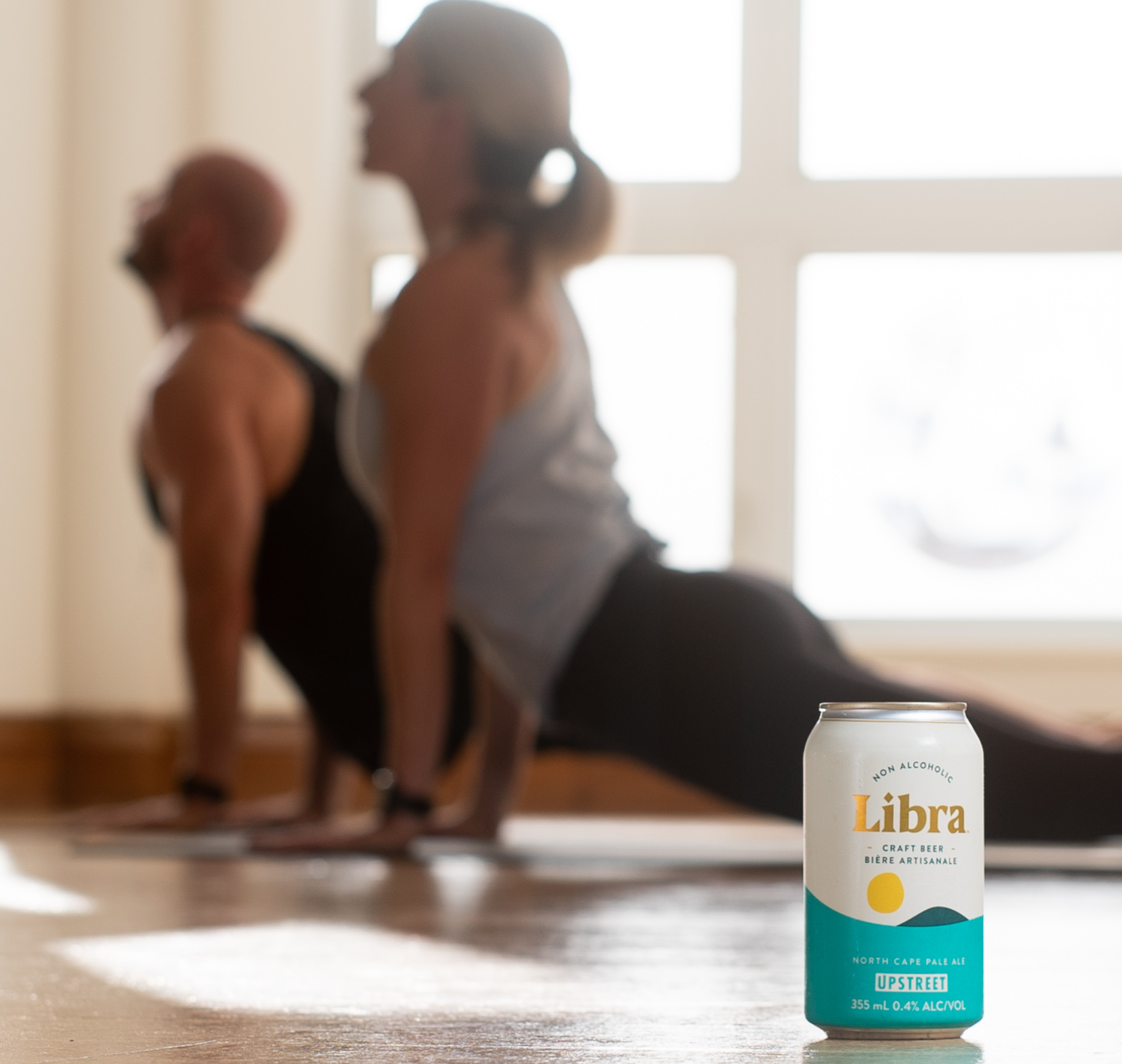 Two woman doing yoga poses. Libra is a craft brewery producing delicious non alcoholic craft beer for any balanced lifestyle.